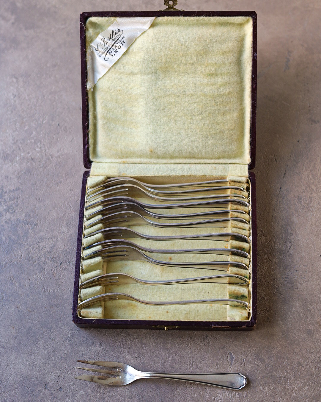 Set di 12 forchettine da dolce mix and match in metallo argentato, Francia, primi '900, con astuccio