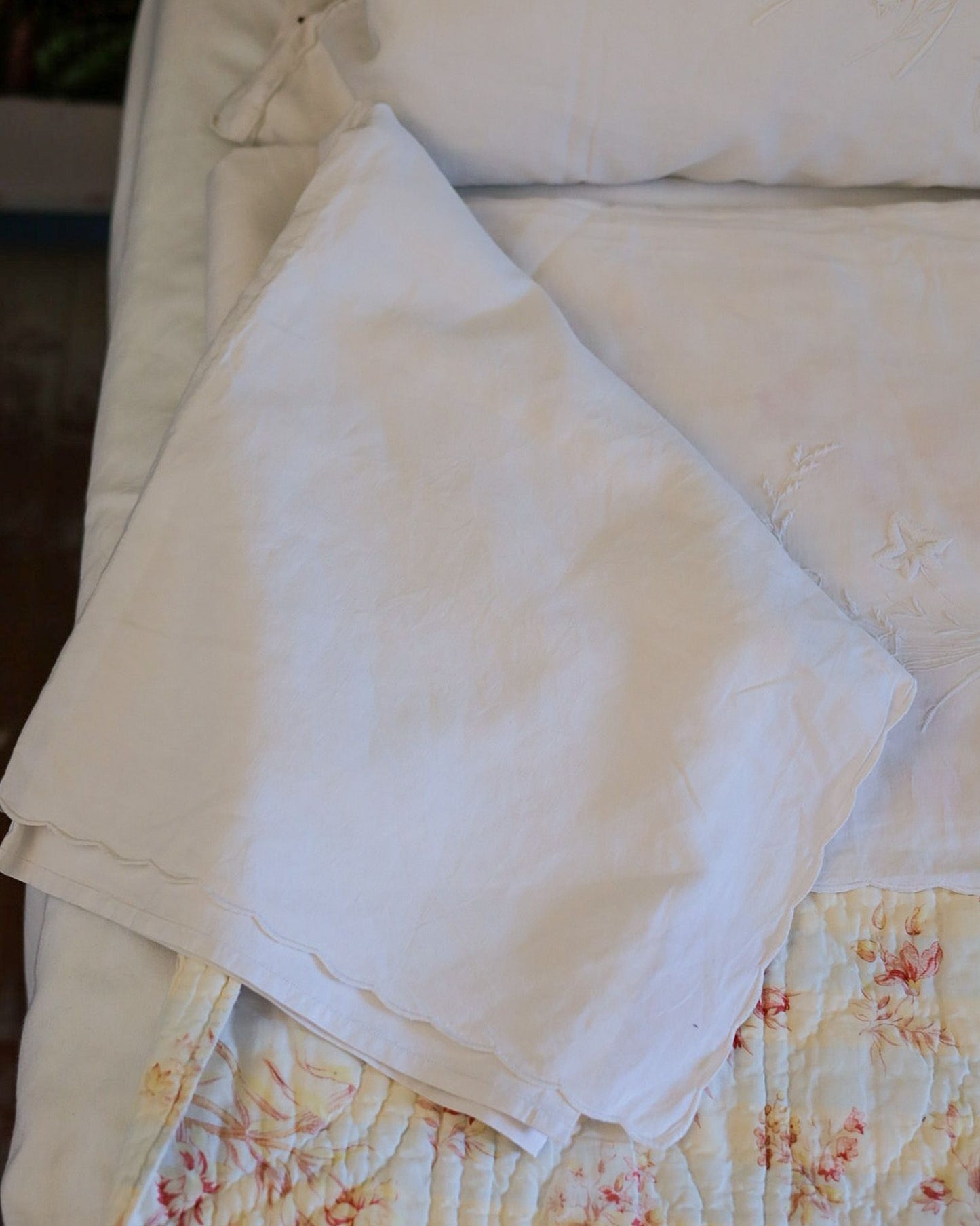 Lenzuolo matrimoniale con due federe — lino-cotone, ricamo bianco su bianco con accenti in filo giallo, Italia prima metà del '900 — cm 242×270, federe cm 80×46